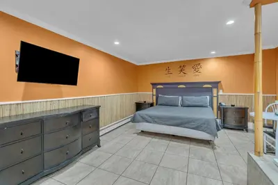 a bedroom with a bed and a flat screen tv at Bentley Motel in Linden