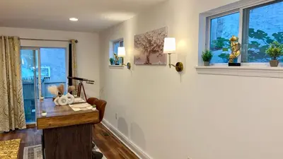 a room with a table and two windows at Spacious Private Ensuite, With Private Bath, Outdoor Space, Workstation, Gym, & All Utilities Included in Point Breeze Home in Philadelphia