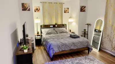 a bedroom with a bed and two tables and a mirror at Spacious Private Ensuite, With Private Bath, Outdoor Space, Workstation, Gym, & All Utilities Included in Point Breeze Home in Philadelphia