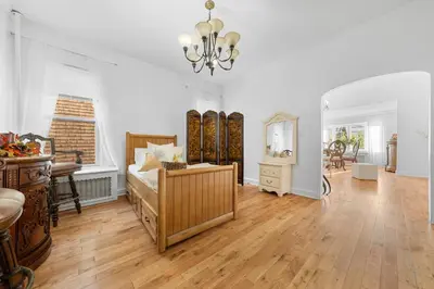 a living room with a bed and a mirror at Quiet Retreat 10 Min to NYC Train & free Parking in Bayonne