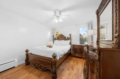 a bedroom with a bed and a mirror at Quiet Retreat 10 Min to NYC Train & free Parking in Bayonne