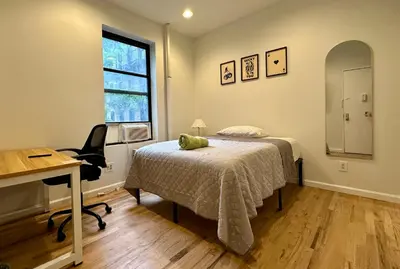 a bedroom with a bed and a desk and a chair at The Marquee House in New York