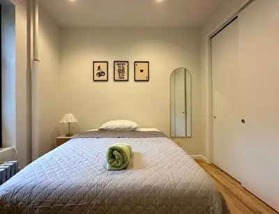 a bedroom with a bed with a green towel on it at The Marquee House in New York