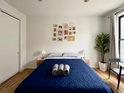 a bedroom with a blue bed with shoes on it at The Marquee House in New York