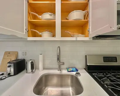 a kitchen counter with a sink and cups and dishes at The Marquee House in New York