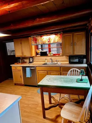 a kitchen with wooden cabinets and a table and a sink at Stony Creek Lodge in East Stroudsburg