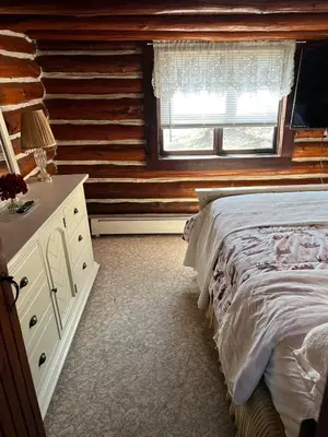a bedroom with a bed and a dresser and a window at Stony Creek Lodge in East Stroudsburg