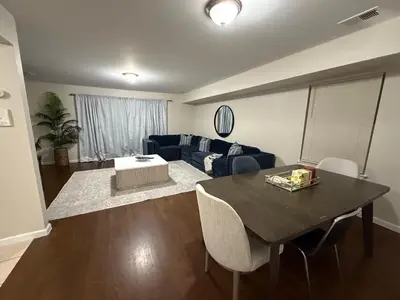 a living room with a table and a couch at Charming Large 3 beds-2 bath Newark EWR NYC in Newark
