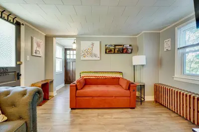 a living room with an orange couch in a room at Little Woodland Home Hidden Gem By Dtwn Bethlehem in Bethlehem