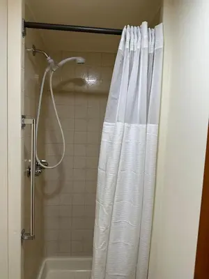 a shower with a white shower curtain in a bathroom at Rutland Hill Farmhouse in Mansfield
