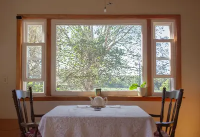 a table with two chairs in front of a window at Rutland Hill Farmhouse in Mansfield