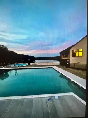 a swimming pool with blue water in front of a building at Chalet Montelago in The Hideout in Lake Ariel