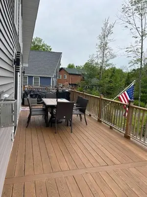 a deck with a table and chairs and an american flag at Chalet Montelago in The Hideout in Lake Ariel