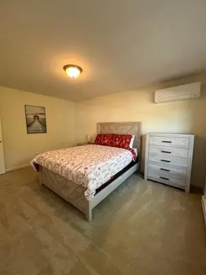 a bedroom with a bed and a dresser in it at Chalet Montelago in The Hideout in Lake Ariel