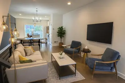 a living room with a couch and a dining room at Modern Riverfront Rowhome, Walk to Fishtown in Philadelphia