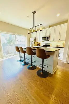 a kitchen with a table and four bar chairs at Modern Riverfront Rowhome, Walk to Fishtown in Philadelphia