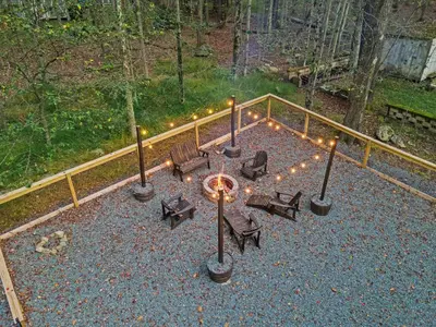 a patio with benches and lights and a fence at Pocono Lake Escape, includes Golf Cart, Firepit in Pocono Lake