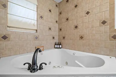 a bath tub with a sink and a window at Pocono Lake Escape, includes Golf Cart, Firepit in Pocono Lake