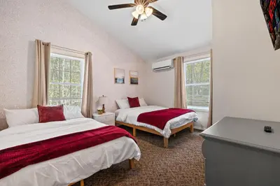 a bedroom with two beds and a ceiling fan at Pocono Lake Escape, includes Golf Cart, Firepit in Pocono Lake