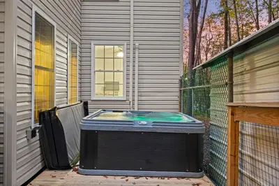 a hot tub sitting on the side of a house at Pocono Lake Escape, includes Golf Cart, Firepit in Pocono Lake