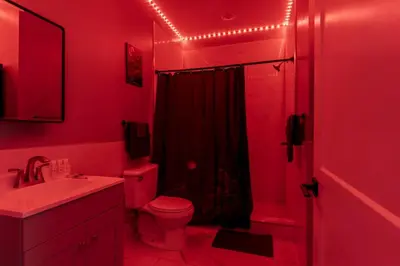 a red bathroom with a toilet and a shower at Lunar Escape 1 Bd Near Zoo, Rocky Steps & Downtown in Philadelphia