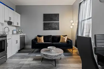 a living room with a black couch and a table at Lunar Escape 1 Bd Near Zoo, Rocky Steps & Downtown in Philadelphia