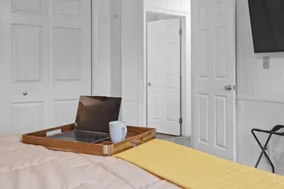 a laptop computer sitting on a tray on a bed at Family Escape with Yard, Fire Pit and EV Charger in Palmyra