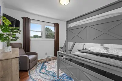 a bedroom with a large bed and a chair at Family Escape with Yard, Fire Pit and EV Charger in Palmyra