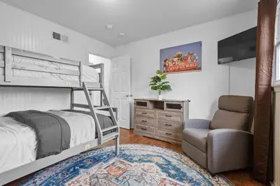a bedroom with a bunk bed and a chair at Family Escape with Yard, Fire Pit and EV Charger in Palmyra