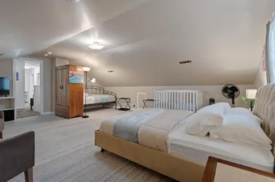 a bedroom with a large bed and a living room at Family Escape with Yard, Fire Pit and EV Charger in Palmyra