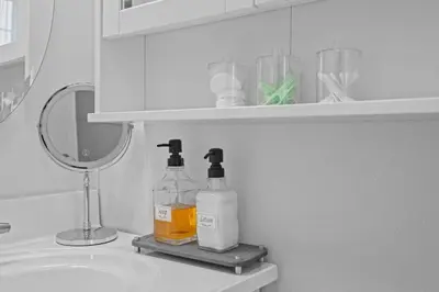 a bathroom with two bottles of soap and a mirror at Family Escape with Yard, Fire Pit and EV Charger in Palmyra