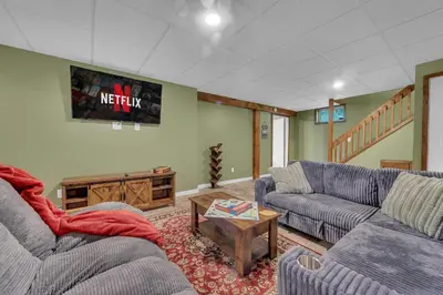 a living room with two couches and a table at Secluded Log Cabin with Hot Tub Fire Pit Game Room in Newfoundland