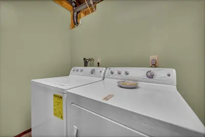 a white washer and dryer in a room at Secluded Log Cabin with Hot Tub Fire Pit Game Room in Newfoundland