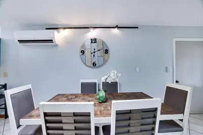 a dining room table with chairs and a clock on the wall at The Playhouse Retreat Large Game Room Fire Pit in Tobyhanna