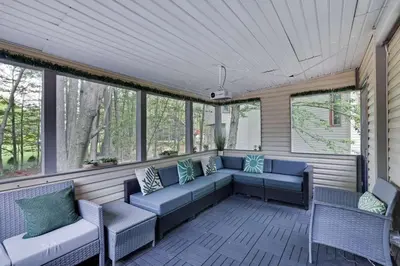 a screened in porch with a couch and chairs at The Playhouse Retreat Large Game Room Fire Pit in Tobyhanna