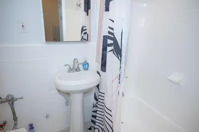 a bathroom with a sink and a shower curtain at Stylish East Village Apartment12 close to Union Square Steps from NYC Best Restaurants & Shops in New York