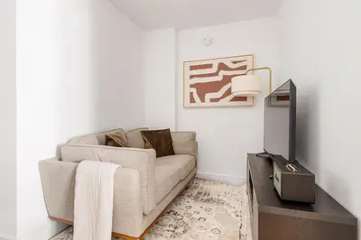 a living room with a couch and a tv at Blueground Midtown East rooftop nr Bryant Park NYC-2070 in New York