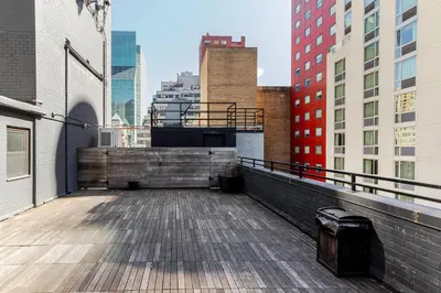 a balcony with a wooden floor and buildings at Blueground Midtown East rooftop nr Bryant Park NYC-2070 in New York