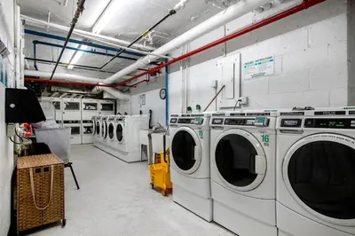 a laundry room with three washing machines in it at Blueground Midtown East rooftop nr Bryant Park NYC-2070 in New York