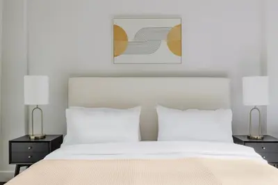 a bedroom with a white bed and two lamps at Blueground Lincoln Square fitness nr Central Park NYC-2102 in New York
