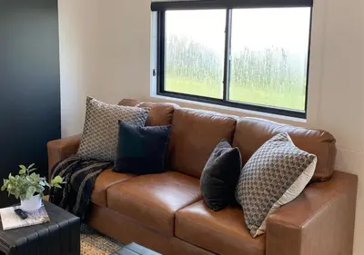 a brown leather couch with pillows in a living room at Tioga Ridge Lookout I Near Tioga-Hammond Lake