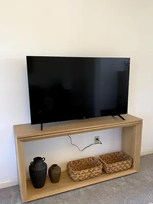 a flat screen tv on a wooden stand with baskets at 11-Acre Retreat I Firepit, Pickleball and Nature