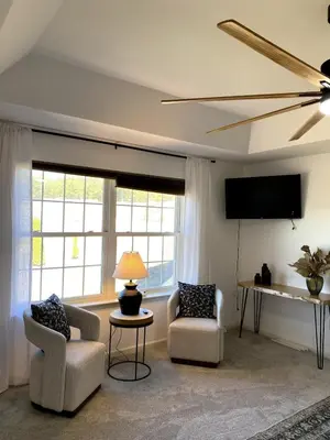 a living room with two chairs and a flat screen tv at 11-Acre Retreat I Firepit, Pickleball and Nature