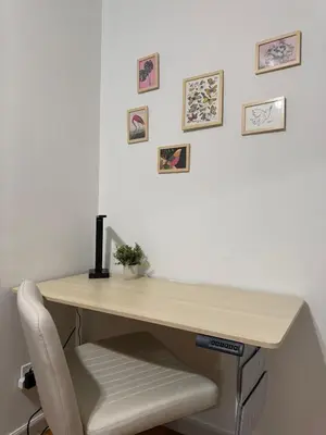 a wooden desk with a chair and pictures on the wall at The Global Nook - Private Room with Shared Bathroom near Times Square in New York
