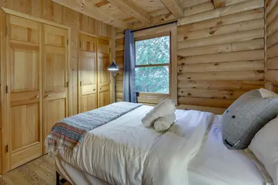 a bedroom with a bed in a log cabin at Year-Round Outdoor Adventures Poconos Hideaway in East Stroudsburg