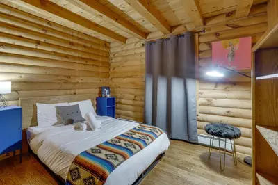 a bedroom with a bed in a log cabin at Year-Round Outdoor Adventures Poconos Hideaway in East Stroudsburg