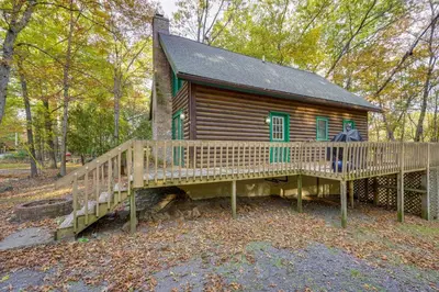 a log cabin in the woods with a large deck at Year-Round Outdoor Adventures Poconos Hideaway in East Stroudsburg