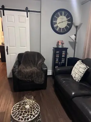 a living room with a couch and a clock on the wall at The Layover Lounge in Elizabeth