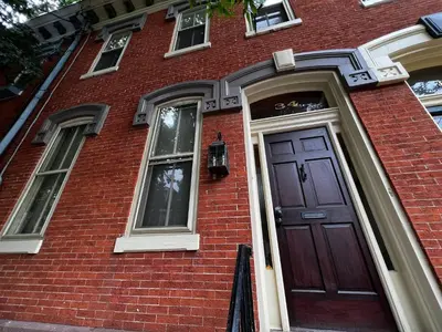 a red brick house with a brown door at THE WINTER HOUSE - HISTORIC DOWNTOWN LANCASTER in Lancaster