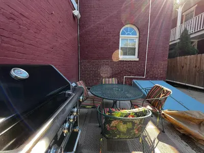 a grill with a table and chairs next to a building at THE WINTER HOUSE - HISTORIC DOWNTOWN LANCASTER in Lancaster